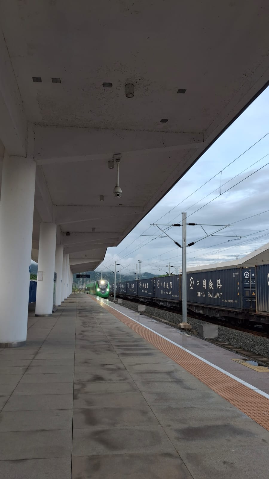 Rame verte de voyageurs et convoi de conteneurs China Railway en gare de Luang Prabang